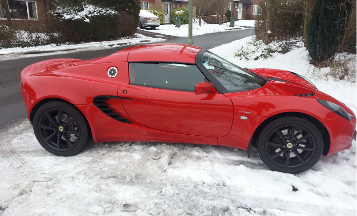 A red car is parked in a parking lot - Pistonheads