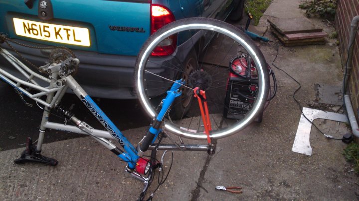 Pistonheads - The image captures a scene of outdoor activity, focusing on a blue bicycle and a black car. The bicycle is situated on an outdoor floor next to the car. The car appears to be parked, and the bicycle seems to be in the process of being secured or propped up near the vehicle. The image's composition suggests a casual, everyday setting.