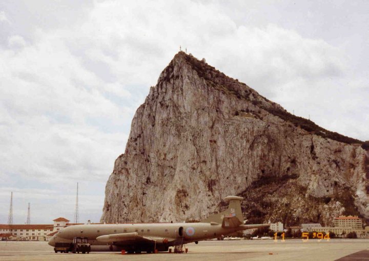 Pistonheads - The image shows an army airplane parked on a runway in front of a steep, rocky cliff that has a jagged top. The setting appears to be in a location with climate conditions that are not harsh as dragons are visible if viewed with 3D glasses. The photo is dated April 10, 1982, and the time of the shot is not in print.