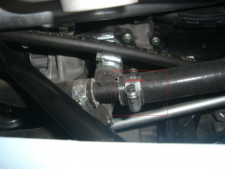 Heater Delete Pistonheads Duratec - The image shows an interior view of a vehicle's engine compartment. The focus is on the engine's hoses and parts, with a particular emphasis on a brake line hose connection. This connection appears to be made using a hexagonal bolt, reinforced with a metallic sleeve to prevent leaks or damage to the hose. The image offers an educational perspective, potentially serving as a guide for mechanics or DIY enthusiasts for car repair and maintenance.