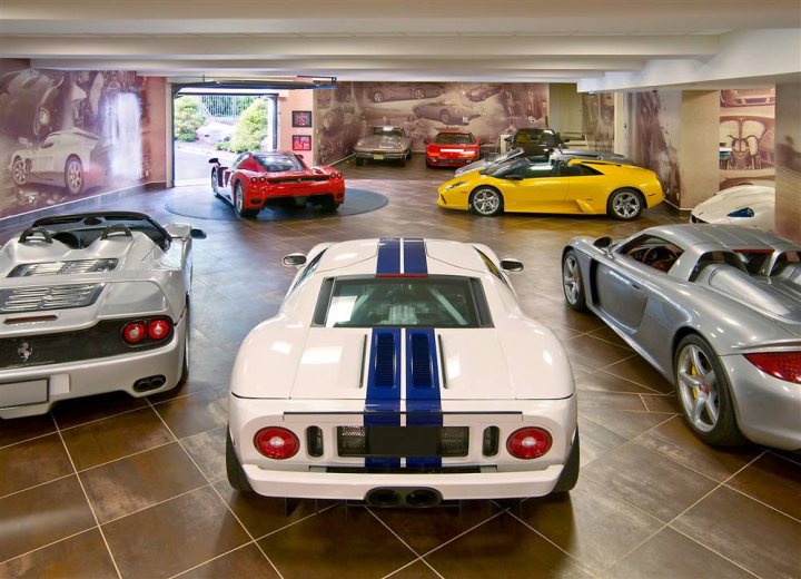 Who has the best Garage on Pistonheads???? - Page 122 - General Gassing - PistonHeads - The image showcases a showroom filled with a variety of luxury cars. There are several Ferraris, each displaying a unique color and model, and they're arranged in a semi-circle formation. The floor beneath is a mix of brick and concrete, adding an industrial touch to the elegant presentation of these automotive marvels. Furthermore, the artful arrangement of the vehicles allows for easy viewing and comparison, showcasing their distinct features and design. The overall ambiance of the showroom is one of sophistication and exclusivity.