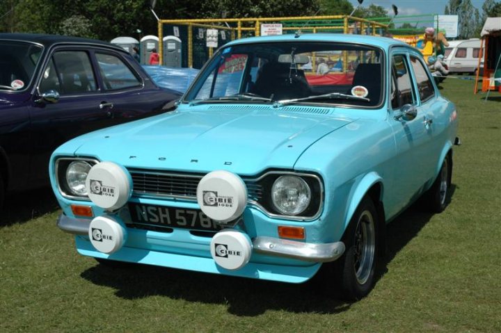 Fins and Chrome - Page 1 - North East - PistonHeads - The image showcases a unique, historic baby blue car with distinctive round headlights and a licence plate that reads "N578". The car is parked on a grassy area with other recreational vehicles in the background. The vehicle's vibrant color and size differentiate it from the other cars and vehicles in the vicinity.