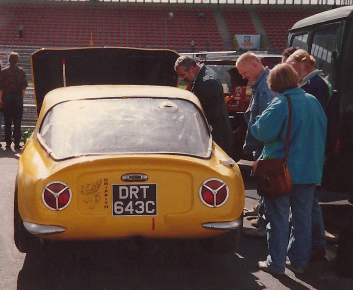 Early TVR Pictures - Page 10 - Classics - PistonHeads - In the image, there's a gathering centered around a distinctive yellow car with the registration plate "DRT 643C". This vehicle appears to attract attention, possibly due to its color or the age model. The car manufacturer is noted as Auto Union, which might raise interest. The scene is populated with people, some of whom are standing around and inspecting the car, indicating it's on display or the subject of interest. This setting suggests that this could be a car show or a similar motoring event.