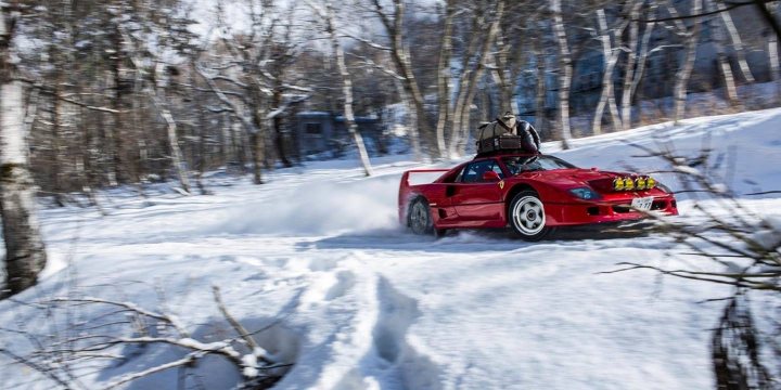 The camera can capture some fantastic moments IV - Page 498 - Photography & Video - PistonHeads - The image depicts a dynamic winter scene. A red sports car is driving down a snow-covered road, leaving a trail of snow dust in its wake due to speeding. The car's fast movement creates a contrast against the still snow, which not only covers the ground but also decorates the trees lining the road. The tracks left by the vehicle suggest it might be the first car to traverse this route after fresh snowfall. There's a sense of speed and excitement, with the car reaching a right turn where the driver can be seen behind the windshield, continuing the journey.