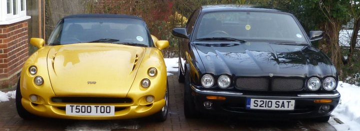 Votes please, which two to keep? - Page 1 - General Gassing - PistonHeads - This image captures a vibrant scene of a driveway, where two cars are parked side by side. The car on the left is a striking yellow convertible, its top down, revealing the driver's seat. It's a sleek and modern vehicle, possibly a special edition or a sports car, given its styling. The car on the right is a more traditional four-door sedan, predominantly black in color, and it's equipped with a UK-style license plate.

The cars are parked on a brick driveway that adds a rustic charm to the scene. The driveway extends into the background, suggesting a large property or perhaps a home in an urban or suburban area.

Trees line the driveway, their branches heavy with leaves, indicating that it might be autumn or winter. The trees provide a natural backdrop to the parked cars, juxtaposing the man-made vehicles with the beauty of nature.

Despite the differences in their appearances and types, both cars seem to share the driveway peacefully, perhaps hinting at the friendliness of the neighborhood or the drivers themselves. The image exudes a sense of tranquility and orderliness, each car in its