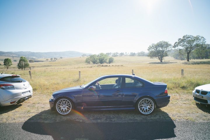 Sellers remorse :( - Page 13 - General Gassing - PistonHeads - The image depicts a tranquil sunny day in an open field with a hill in the distance. Dominating the scene is a shiny, dark blue BMW coupe, parked at an angle on a gravel surface. Its sleek design and glossy finish reflect the sunlight, giving it an almost ethereal presence. Parked behind the BMW is another car, smaller and less shiny, blending harmoniously into the natural setting. The third car, barely visible due to its position on the far left of the frame, adds to the overall image of a calm outdoor gathering. The blue sky, the light pouring from the upper left corner of the photo, and the picturesque setting evoke a sense of serenity and admiration for the vehicles and nature cohabiting the scene.