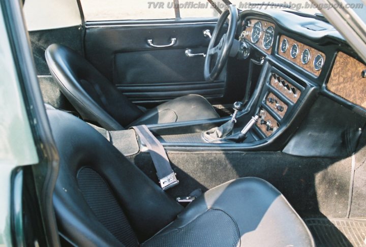 Grantura Griffith Vixen Tuscan Dash Pictures - Page 1 - Classics - PistonHeads - The image captures the interior of a black classic car. The dashboard is prominently visible and features a variety of gauges and controls. The chair driver side is empty, inviting the viewer to imagine themselves in the driver's seat. The back seat and passenger door are also clearly visible. The car's interior offers a sense of luxury and comfort.