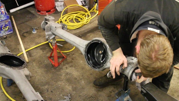 A man standing next to a fire hydrant - Pistonheads - The image captures a man engaged in a repair activity on a complex machine. He appears focused and is in the process of working on the machine, surrounded by tools and equipment. His workspace is messy and almost resembles a junkyard, hinting at the intensity and rigor of his work.

The machine in focus is white, and it looks like a sophisticated kind of machinery or appliance. The man's position relative to the machine suggests that he might be studying or servicing it.

In the background, there's a red reflector adding a splash of color to the otherwise monotonous industrial setting. This indicates that the area might be difficult to navigate, necessitating added safety measures.

The setting is industrial, characterized by a large workshop or garage. The man seems to be in his element, absorbed in his work.