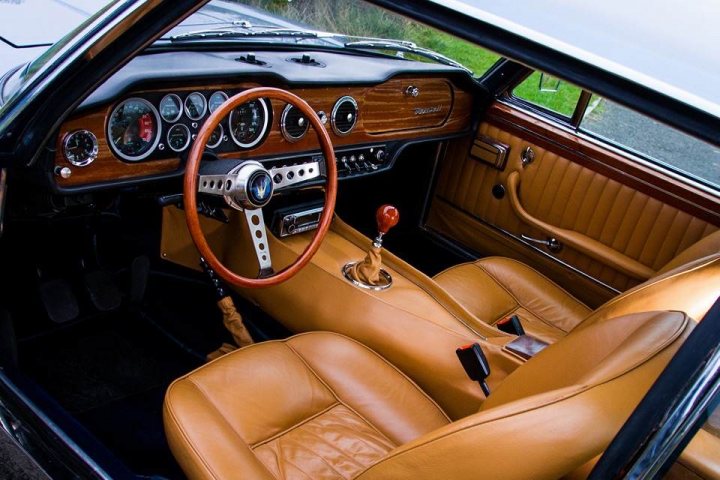 Lets see a picture of your classic(s) - Page 282 - Classic Cars and Yesterday's Heroes - PistonHeads - This image features a luxurious retro vehicle's interior, captured from the driver's perspective. The focus is on the open driver's side door, revealing a yellow leather interior that gleams in the light. The steering wheel, which is also made of yellow leather, is visible, positioned in the center. The dashboard and control knobs, reflecting the vintage style of the vehicle, are visible against the darker colors of the car. The overall feel of the image is one of comfort and luxury.