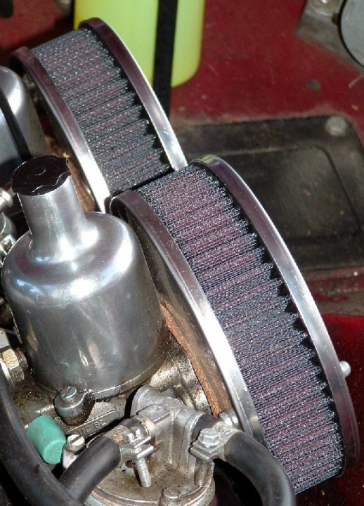 Pistonheads - The image shows a close-up of an engine component, featuring a significant presence of a metal filter or pulley and an air filter. The filter appears to have a series of grooves or ridges, which are typical characteristics for air intake filters to trap debris and obstructants from entering the engine's airflow system. This part of the image is in focus, showing details of the ridges and the texture of the material, while the background is blurred, drawing attention to the foreground filter. The colors in the image are interplayed, with metallic hues from the filters against the darker colors of the engine and surrounding parts. The image has a mechanical and industrial feel, indicative of engine-related equipment.