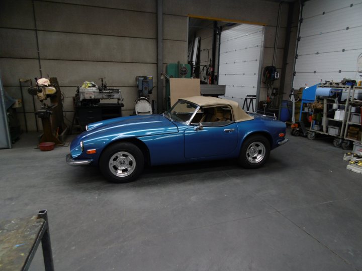 A white truck parked in front of a building - Pistonheads - The image depicts a classic blue Maserati car parked inside an industrial garage or workshop. The vintage Maserati, characterized by its distinctive side vents and narrow front grille, is in need of new paint. Its convertible top is raised, and a single person is visible inside, hinting at the possibility of restoration or repainting work being in progress. Surrounding the car is a collection of tools and equipment, suggesting a setting familiar with automotive work. In the background, white walls and a high ceiling hint at an expansive, well-lit space.