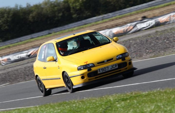 A yellow and black car is parked on the side of the road - Pistonheads