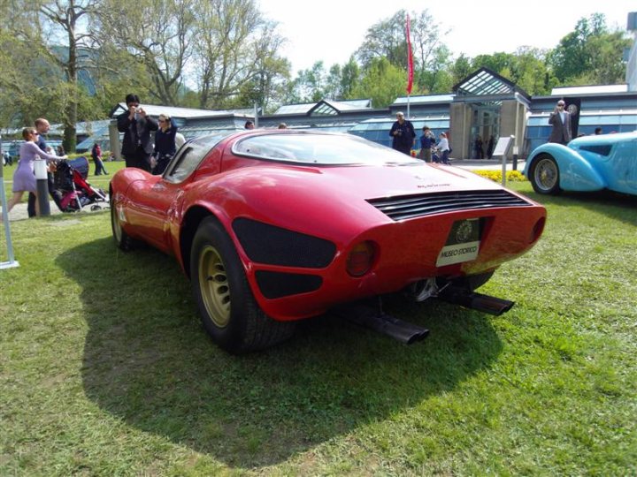 Pistonheads Villa Deste Concoursporn - The image presents a vibrant outdoor scene, featuring a striking red Ferrari parked on a well-maintained lawn. The Ferrari, with its sleek design and prominent badge, is the focal point of the image. Around the parked Ferrari, the grass is lush and green, and an open sky can be seen in the background.

In the vicinity, there are several people present. A group of people can be seen walking by the Frenc sports car, perhaps admiring it or preparing for an event. Also noticeable is a vintage car in the distance, hinting at a possible car show or gathering.

The scene is set against a backdrop of lush trees and clear skies, creating an inviting atmosphere. This outdoor gathering seems to be taking place in a greenfield or a large open parking area, emphasizing the typical automobile-related events that often involve such settings.