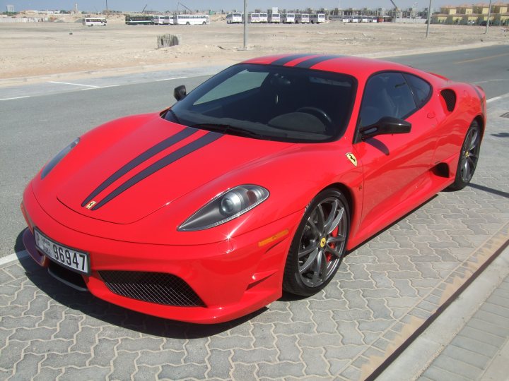 My First Ferrari...and its a Scud! - Page 1 - Ferrari V8 - PistonHeads - The image features a vibrant red Ferrari car, parked on a street. The car's paint reflecting the bright sunlight indicates it's a sunny day. The license plate of the Ferrari reads "86947". The backdrop of the scene is composed of a dry, desolate plain under a clear blue sky.