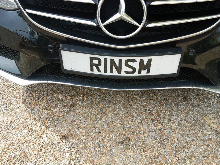 What crappy personalised plates have you seen recently? - Page 340 - General Gassing - PistonHeads - The image shows a close-up of the car's registration plate, which is held by a Mercedes-Benz grille, featuring the iconic logo of three interlocked overlapping lines. The writing on the plate reads "RINSM," suggesting it might indicate the car's make or is possibly an abbreviation. The car appears to be stationary, given its neutral position from the perspective of the photo, which is taken from above. The ground beneath the car seems to be a gravel or dusty surface, indicating that the car may be in a less urban area or perhaps on a temporary tracking device.