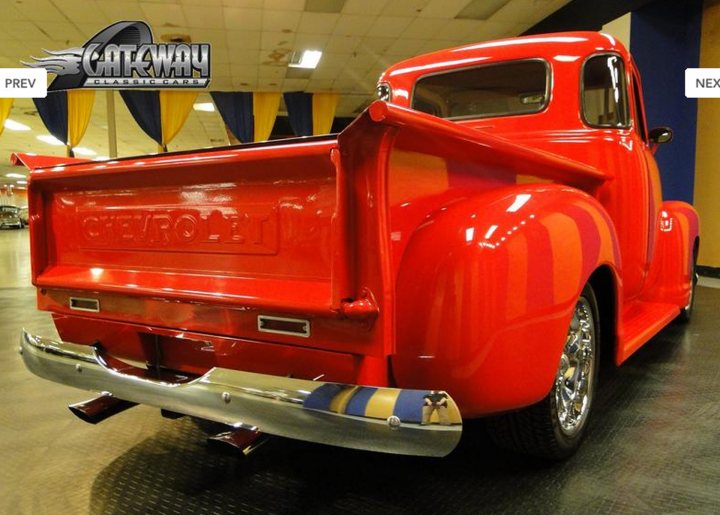 Pistonheads - The image showcases a vintage red Chevrolet pickup truck, its rich hue reflecting off the smooth black floor. The truck rests quietly in a spacious garage, adorned with a yellow bunting that hangs elegantly from the ceiling. Another bunting, this one blue, is visible in the background, adding a pop of color to the scene. The vintage model of the truck, a classic two-door crew cab, gives a sense of nostalgia. Despite the indication of "Next Prev", there is no indication of a newer pre-owned model in the scene.