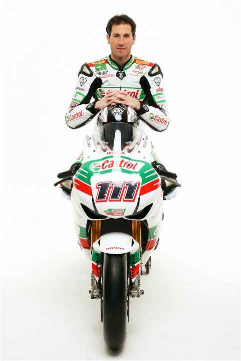 Castrol Craig Pistonheads Fao - This is a portrait-style photograph of a male motorcycle racer. He is wearing a full racing suit, including gloves, helmet, and boots, which are adorned with various sponsor logos and text. The racer is seated on a motorcycle with the number 1 on the front, suggesting he is likely a professional or competitive racer. The style of the image is clean and professional, typical of motorcycle racing media.