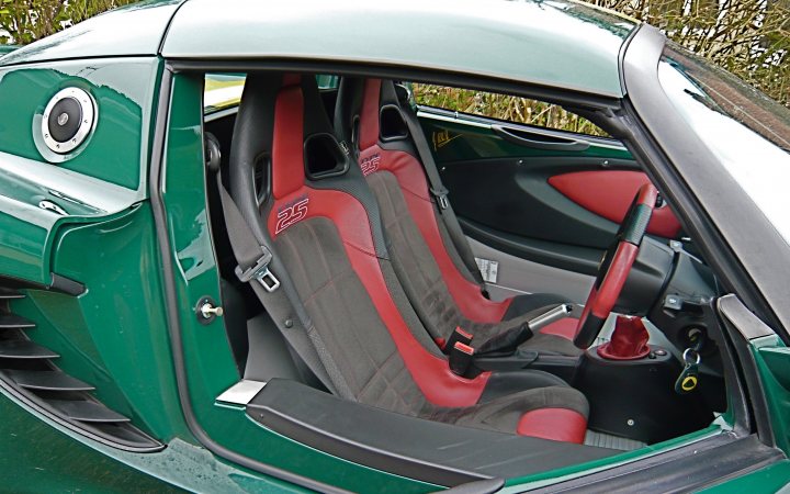 Best car interiors - Page 7 - General Gassing - PistonHeads - The image showcases the interior of a green car, where the focus is on the driver's seat. The seat is adorned in red and black fabric, indicating a sporty style. A prominent feature in the car is the steering wheel, positioned centrally and ready for use. Besides, there are two visible side mirrors, one on each side. The presence of black accents adds a sleek touch to the overall design.