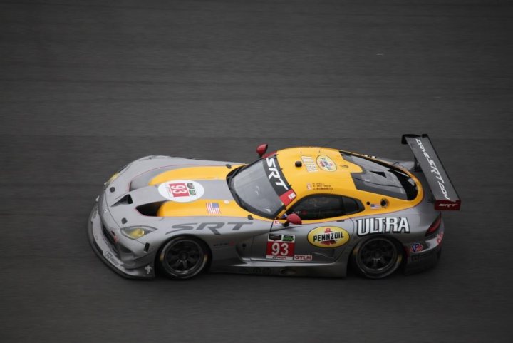 A red and white motorcycle parked in a parking lot - Pistonheads - This image captures a dramatic moment on a race track. At the center of the frame is a racing car, its body painted in vibrant shades of yellow and gray. The car is in motion, as indicated by the blurred background, suggesting it is moving at high speed. 

The track itself is a dark shade of gray, the paint worn from previous races, and it curves subtly through the composition, adding a sense of dynamic movement to the scene. 

The car is adorned with various sponsors' logos, including a prominent one on the hood that reads "UTRA". These logos not only add visual interest but also hint at the competitive nature of this sport. 

Overall, the image conveys a sense of intense action and excitement, characteristic of high-speed racing events.