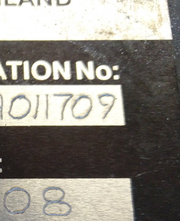 Production start and VIN numbers - Page 3 - Griffith - PistonHeads - The image features a close-up view of a small label or tag with handwritten text. The text on the tag reads "ELECTRICITY NUMBER" followed by an identification number "1709". Below this, there is an additional piece of information indicating "FUEL PAYMENT". The background is mostly black, but there appears to be a blurred object with a yellow label that says "1825".