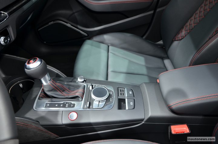 RE: Audi RS3 pricing confirmed - Page 18 - General Gassing - PistonHeads - This image captures the interior of a luxury vehicle, specifically focusing on the cockpit. The central feature is the center console with various buttons and a gear shift lever of a car. In this case, the vehicle is described as a convertible, which means the car has a convertible top. The dashboard is black, and there are red and gray accents, adding to the plush and sophisticated ambiance of the car's interior. Accompanying the gear shift lever are additional controls, including an audio control panel, demonstrating that the car is indeed a convertible with an advanced infotainment system. The overall layout of the controls and the aesthetic appeal of the upholstery suggest that this is a sports car with a multitude of features for the driver's convenience and enjoyment.