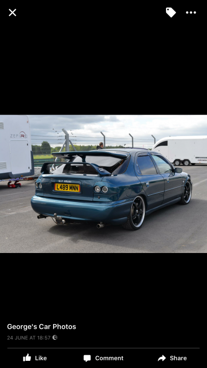 Badly modified cars thread Mk2 - Page 253 - General Gassing - PistonHeads - The image shows a blue car with a rear spoiler at a car show. The backdrop is clear, allowing the vehicle to be the focal point. There's a person at the show, adding a sense of scale to the image. On the side, there's a van, suggesting a size comparison between vehicles. The setting appears outdoors, with an overcast sky and smooth pavement.