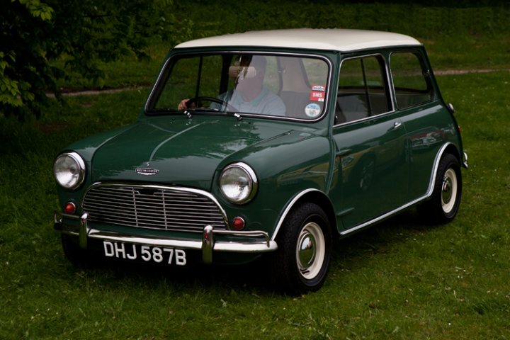 London to Brighton  - Page 1 - Classic Minis - PistonHeads - The image captures a striking vintage green mini cooper car, parked alone on a lush grassy field. The car is of the classic graduated pint pattern of vintage minis, a design characteristic known for its immediate recognition. The registration number of the vehicle reads "DHJ 587B", and a "Free" label is affixed to the sun visor, possibly indicating a for-sale status. The car, currently unoccupied, is viewed from a perspective that showcases its iconic design while also revealing its solitary surroundings.