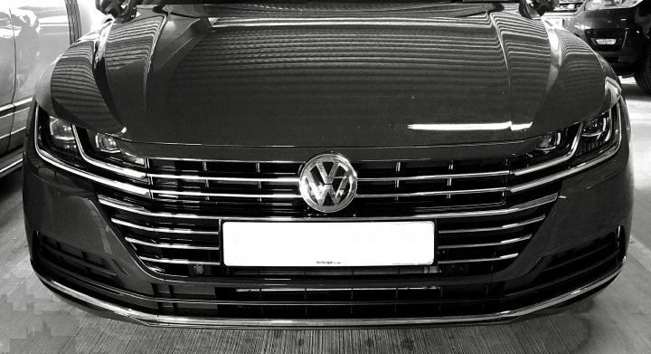 The Arteon lease thread - Page 37 - Audi, VW, Seat & Skoda - PistonHeads - The image shows a black Volkswagen sedan parked indoors. The car has a sleek design with a large grille and alloy wheels. The vehicle is positioned facing the viewer, and there's no other object or person in the foreground. In the background, another car can be seen, indicating that this could be a showroom or parking lot. The lighting inside the building gives off a calm atmosphere.