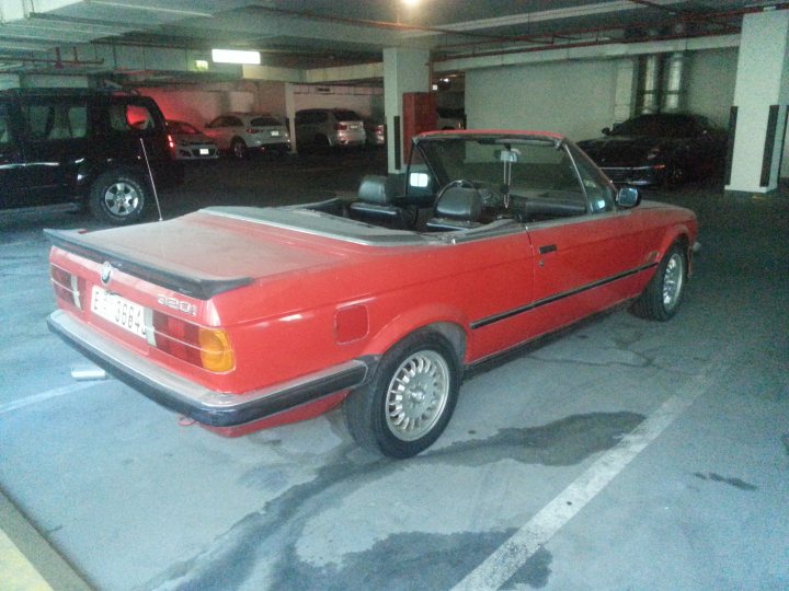 Middle East spotted thread - Page 53 - Middle East - PistonHeads - The image depicts an outdoor parking lot, dominated by a prominent red Toyota Carina. The car is positioned in the foreground, with its gray roof and shiny black leather seats adding contrast to its vibrant exterior. Behind it, the multi-level garage structure reveals several parked cars. A sign in the garage area is partially visible and reads, "24Hrs, Operating daytime." There is a watermark on the image indicating that the photo was taken with a six-megapixel camera, suggesting that the image may have been taken by the owner or a guest.