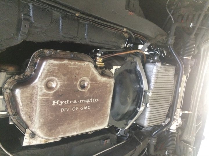 Lets see a picture of your classic(s) - Page 1 - Classic Cars and Yesterday's Heroes - PistonHeads - The image shows the underside of a vehicle's engine compartment, focusing on the engine and some wiring or hoses. There is a visible logo that reads "HYDRA MATIC." The photo appears to be taken with a flash, as indicated by the reflection in the metal components of the car. The background is dark and out of focus, emphasizing the details of the engine.