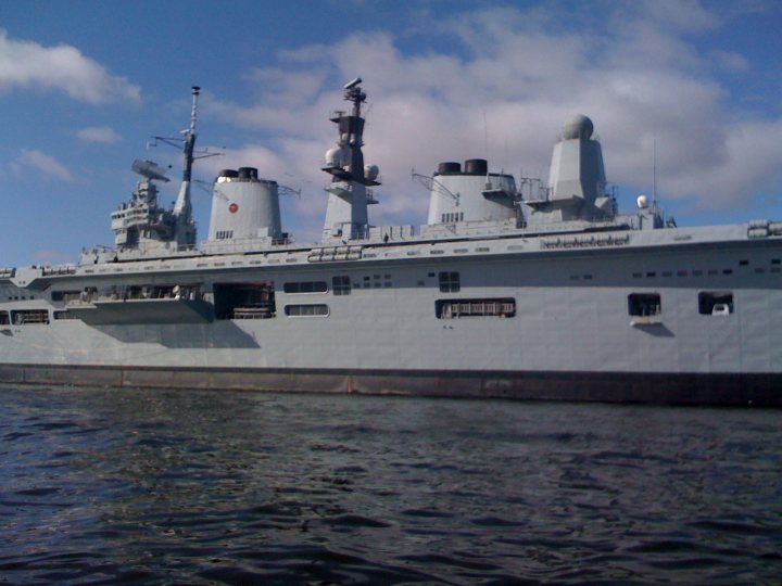 Amazingly Boats Pistonheads Ships - The image captures a large military ship, which appears to be a war destroyer based on its slender and streamlined hull. The ship is camouflaged in white, and it features numerous domed structures and antennas, suggesting advanced technological capabilities. The ship rests on a body of water, possibly preparing for deployment or returning from a mission. The weather is fair with a blue sky lightly adorned with clouds, suggesting a serene day at sea. The ship is not in motion, as indicated by its stable position against the backdrop of the water and sky.