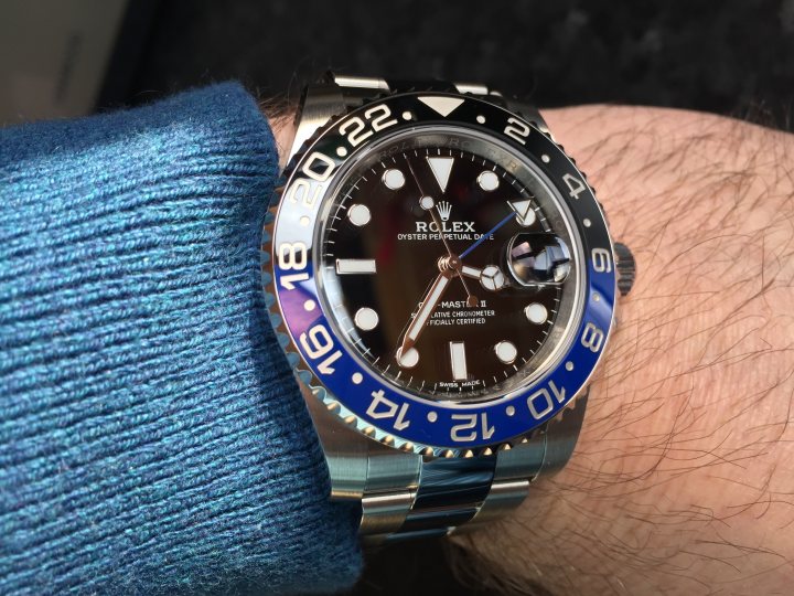 Wrist Check - 2018 - Page 29 - Watches - PistonHeads - The image captures a close-up view of a wristwatch with a blue face panel worn by a person. The watch features a date window, a tricolor crown emblem, and a tidal force indicator that are typical of some Rolex models. The person's hand, in the shot, wears a blue cloth sleeve, suggesting they might be wearing a suit or a long-sleeved shirt with matching blue detailing. The watch itself is positioned on the left side, accentuating its prominence in the image.