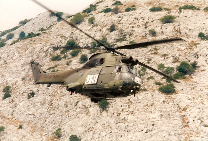 Post amazingly cool pictures of aircraft (Volume 2) - Page 81 - Boats, Planes & Trains - PistonHeads - This image captures a moment in mid-flight featuring a military helicopter. The helicopter, which is predominantly green and gray in color, is in flight over a rocky landscape. At the back of the aircraft, a stabilizer is visible, providing counterforce to maintain balance during the flight. The helicopter appears to be in the process of landing or taking off, as indicated by the blurry motion of the rotor blades. The rugged terrain in the background suggests that the flight path is in a mountainous or rocky area.