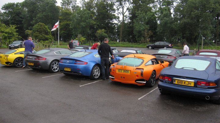 Pistonheads - The image captures a parking lot filled with a variety of cars. There are six cars in total, each with its own distinct shape and color. Four of the cars are shades of blue, one is yellow, and another is orange. Having noticed a couple of individuals in the background, the people in the cars appear to be waiting their turn. The overall scene suggests a casual gathering, perhaps a car show or a meet-up for car enthusiasts.