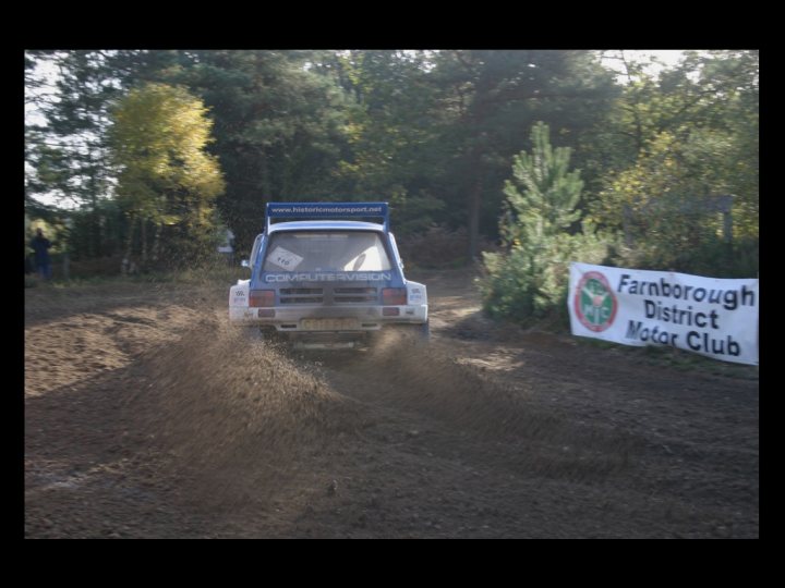 Tempest Rally tomorrow. Anyone on here going? - Page 1 - Thames Valley & Surrey - PistonHeads - This image captures an exciting scene of a car rally or race. The car appears to be an SUV, kicking up a significant amount of dust and mud as it travels down a dirt track towards a sign indicating it's part of the Farnborough District Motor Club rally. The location seems to be a wooded track, with trees visible in the background. The overall atmosphere is one of energetic motion and competition.