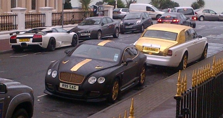 It was gonna happen sooner or later! Re-pimping the Bentley! - Page 25 - Readers' Cars - PistonHeads - The image captures a bustling city street filled with various cars and a truck. The main focus is a unique black car with gold and white stripes. It's parked, hinting at a slower-paced moment on this busy street. Despite the cars moving in opposite directions on either side of the road, the image suggests a sense of order and mechanism. The yellow taxis with black and orange stripes are another remarkable feature, adding a splash of color to the scene.