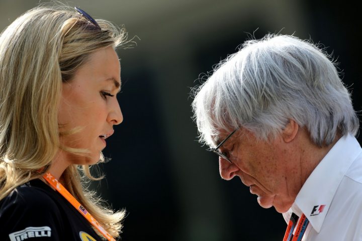 Carmen Jorda on Sky F1 show - Page 1 - Formula 1 - PistonHeads - The image is a candid photograph of two individuals appearing to be engaged in a conversation. The person on the left has blonde hair and is wearing glasses and a black top with orange lanyard. The person on the right has silver/gray hair and is wearing glasses as well, with a white shirt partially visible. They are both outdoors, as suggested by the overcast sky in the background. There is an indistinct logo visible, but there's no text to provide additional context.