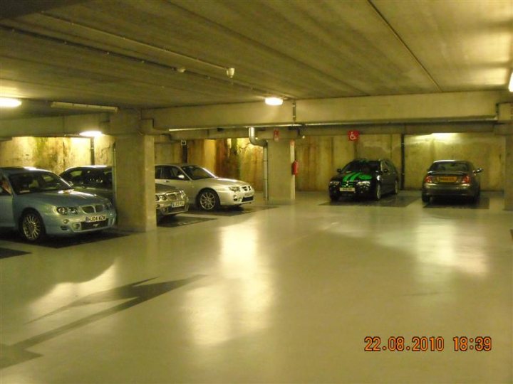 Pistonheads - The image shows a tightly packed underground parking lot with vehicles parked from right to left on the right side of the frame. The cars are models like Audi and Mini Cooper, suggesting they are made in the first two decades of the 21st century, possibly by their respective automakers. The lighting is artificial, creating reflections on the sturdy concrete floor. In the bottom right corner, there is a timestamp indicating the date "22.08.2010" and the time "18:39", suggesting that the image was taken shortly after noon on August 8th, 2010.