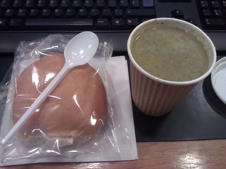 A bowl of soup and a sandwich on a table