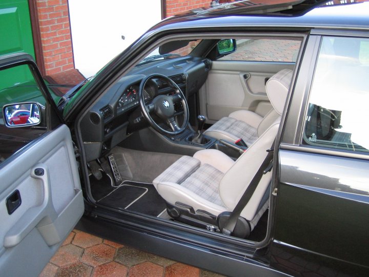 Contribution Pistonheads - The image provides a close-up view from the driver's side of a car, revealing the interior cabin. To the left, you can see a person's door, indicating that two doors are visible. The dashboard of the car has contours designed for practical use. The gear stick, a critical element within the vehicle, is also clearly visible. The car's interior materials and colors suggest a luxurious and well-maintained design.