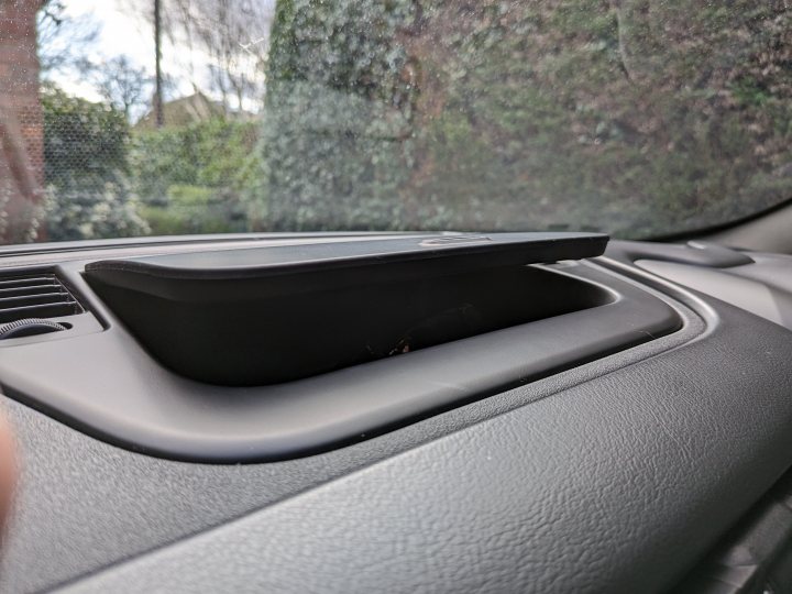 Pistonheads - The image shows a car interior with a focus on the air vent. There is a finger pressing down on the vent. The dashboard of the car is visible, with a cup holder on it. A window, partially covered by what appears to be a bird or a small animal, can be seen in the background. The photo captures the moment from the perspective of someone inside the vehicle.