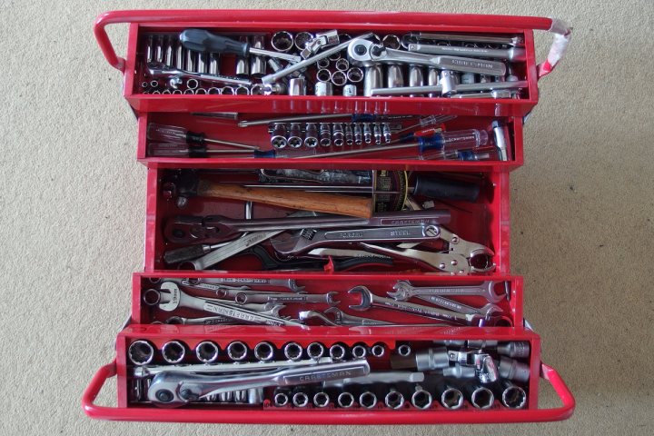 Let's talk tools and boxes - Page 2 - Home Mechanics - PistonHeads - The image captures a collection of tools, neatly arranged inside a red toolbox. Three open trays of the toolbox are visible, revealing an assortment of tools such as pliers, screwdrivers, and spanners. The tools are clean and well-maintained, possibly indicating that they are professionally used. The toolbox is placed on a beige carpeted floor, making the red toolbox stand out prominently in the scene. Overall, the image conveys a sense of organization and precision, characteristic of a dedicated tool user.