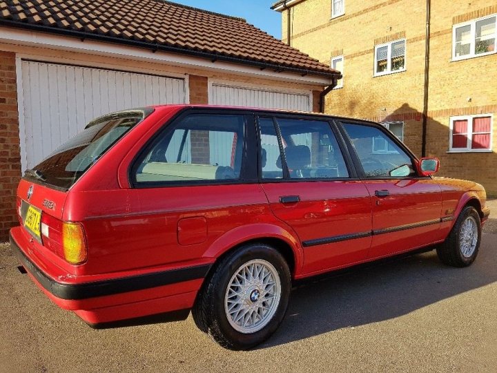 Classic (old, retro) cars for sale £0-5k vol 2 - Page 12 - General Gassing - PistonHeads - The image shows a vibrant classic red car parked in a driveway outside a building. The car has a sleek design with a black bumper and white-walled rims adding to its timeless appeal. Inside the car, there is a handbag and a person driving it visible through the side window. The building and the car together suggest a peaceful and quiet residential area.