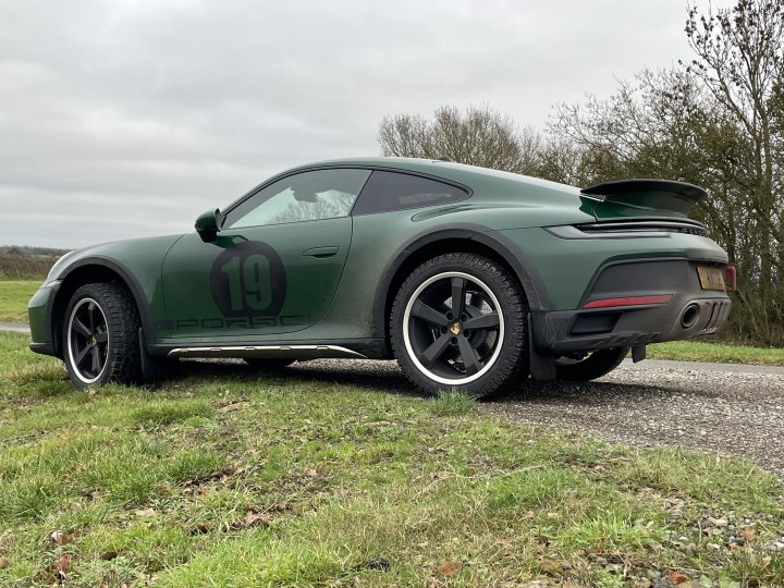 Pistonheads - The image displays a green sports car parked on a grassy area with a paved path. It has the number "19" painted on its side, suggesting it's a race car or a vehicle used in racing events. The car features a sleek design, with a prominent spoiler at the back and black wheels that are visible. The surrounding environment is overcast, indicating possibly cool weather conditions. There are no people visible in the scene.