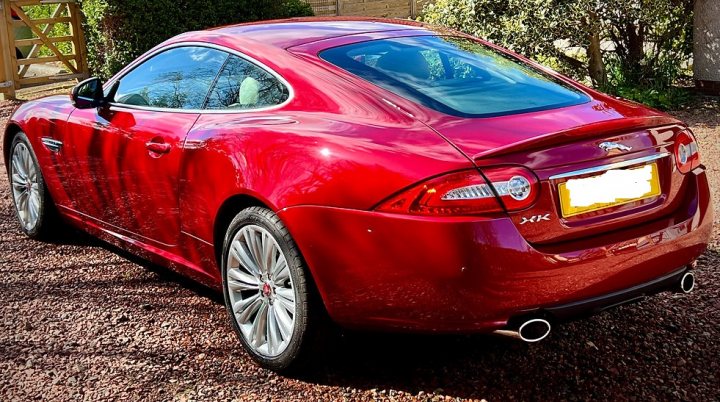 Pistonheads - The image shows a red luxury sedan parked on a gravel surface. It appears to be a daytime photograph with the car being the central focus. The car is equipped with alloy wheels and has visible branding, including a logo on the rear door. There's also a license plate, but it's not clear from the image. In the background, there's greenery suggesting a suburban or rural setting. There's no text present in the image. The style of the car and its surroundings indicate that this could be a promotional photo or a casual photograph taken by an individual.