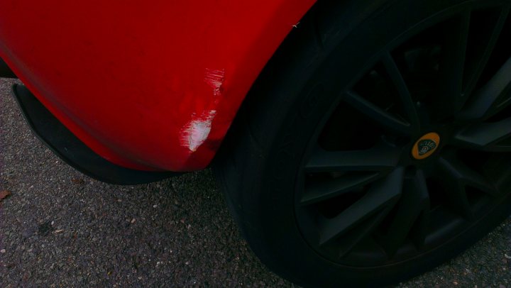 A red and black motorcycle parked on a street - Pistonheads - The image shows a close-up of a tire on a piece of machinery or a vehicle. The tire appears to be made of rubber with a visible groove design meant for traction. There is a logo on the inner rim of the wheel, but the brand and details of the tire are not fully visible. The image is cropped, focusing on the wheel without revealing the surrounding vehicle or equipment.