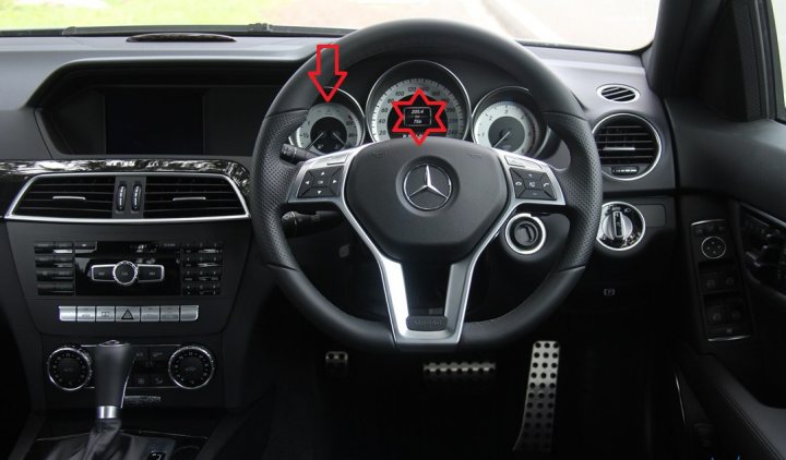 2012 C63 AMG Warning Lights:  Any ideas? - Page 1 - Mercedes - PistonHeads - In the image, we are provided with an interior view of a vehicle, focusing specifically on the steering wheel and dashboard area. The steering wheel, adorned with the Mercedes-Benz emblem, is equipped with a multitude of symbols and buttons, indicating various functions and controls. The dashboard features a digital display, possibly providing information about the vehicle's status. There are two notable red markings, one pointing at the steering wheel, and another pointing at the centre console, presumably cautioning or highlighting certain areas in the car. The car has a sleek, modern design, suggesting that it may be a newer model.