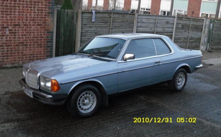 Pistonheads - The image depicts an older, dark-colored sedan parked on a driveway. The vehicle appears to have a metallic finish and a standard, four-door body style. The backdrop consists of a brick wall on one side and a wooden fence on the other. A watermark indicating the date '2010/12/31' alongside a timestamp '05:02' is visible, suggesting the photograph was taken shortly after this date.