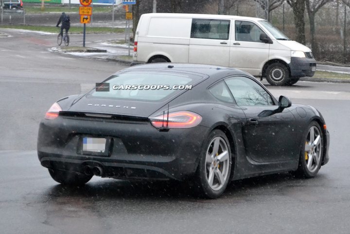 boxster / cayman GTS - Page 1 - Boxster/Cayman - PistonHeads - The image captures a moment on a snowy street where a black Porsche sports car is swiftly passing a white van. The Porsche's rear lights glow from the dark blue exterior, adding a touch of modern elegance to the scene. Just a few feet away, a cyclist is seen navigating the snow-covered road, perhaps admiring the speeding car. In the distance, a person is spotted walking, adding to the urban setting's dynamism.