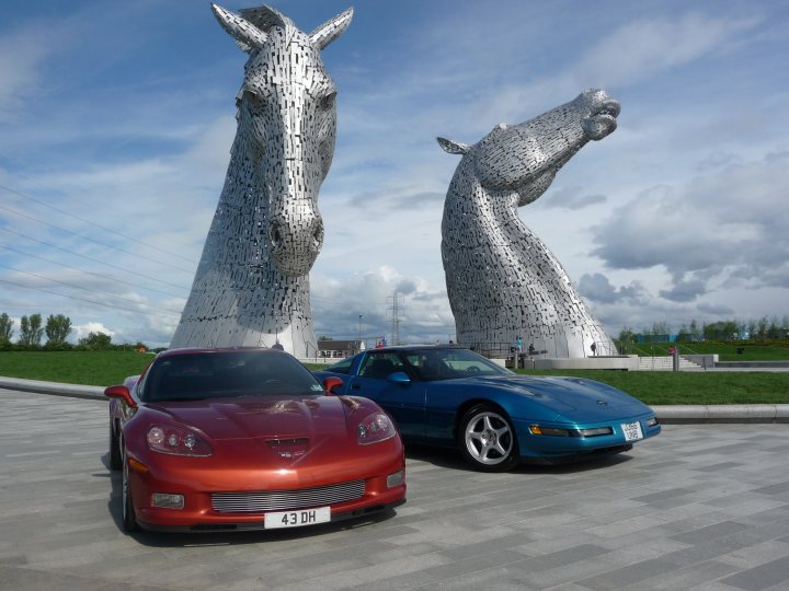 A car that is parked in front of a fire hydrant - Pistonheads - The image captures a striking scene of modern landmarks juxtaposed against the serenity of nature. At the forefront, there are two magnificent horses, sculpted in a style that speaks to the era they were built in. They stand in front of an open area with a lush green lawn that extends into the distance. A sidewalk winds its way through the lawn, inviting visitors to approach and appreciate the artistry. Parked on the sidewalk are two cars, one red and one blue, adding a dash of vibrant color to the otherwise tranquil scene. The presence of the cars suggests that this location is frequented by tourists and locals alike. The relative positions of the horses, lawn, sidewalk, and cars create a harmonious balance within the image, complementing the majesty of the horses and the inviting nature of the lawn.